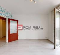A room in a 4-room apartment with a balcony and a wallpaper with inscriptions on the wall.