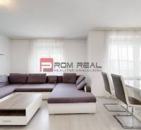 Living room with corner seating in a 4-room apartment, complemented by a table and chairs.