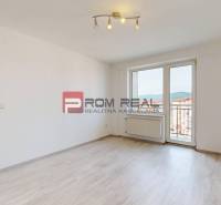 A spacious living room with flooring and access to a balcony in a 4-room apartment.