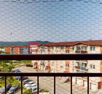 View from a 4-room apartment on Muškátová Street in Pezinok with a parking lot and buildings.