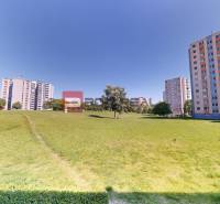 Greenery and high-rise buildings on Koprivnická 9/F, Bratislava IV, with an open space for relaxation.