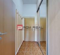 Storage space and a mirror at the entrance in a studio apartment with ceramic flooring.
