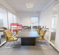 Modern offices with glass partitions, light furniture, and windows.