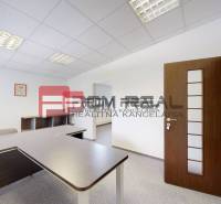 Offices with a desk and chairs, white walls, and a light ceiling.