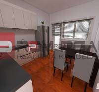 A kitchen in a 3-room apartment with a dining table and a modern kitchen unit.