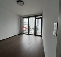 A spacious room with wooden flooring and large windows in commercial premises.