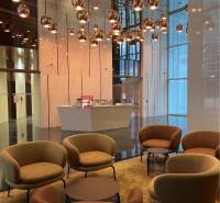 A stylish interior with comfortable armchairs, pendant lights, and a reception area in commercial premises.