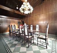 Dining room with a wooden ceiling and paneling, a massive table on Ľ. Podjavorinská, an impressive building.