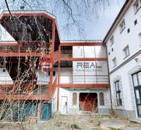 A building on Ľ. Podjavorinská Street in Trnava with an exterior metal staircase and glass windows.