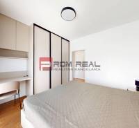 Bedroom in a 2-room apartment with a bed, wardrobe, and desk.