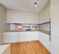 Kitchen unit in a 2-room apartment with wooden flooring and white cabinets.