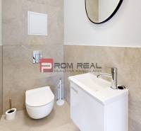 Bathroom in a 2-room apartment with a toilet, sink, and mirror.