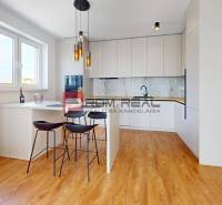 A kitchen in a 2-room apartment with a spacious countertop and wooden floor.