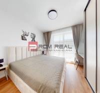 Bright bedroom in a 2-room apartment with a large bed and a built-in wardrobe.