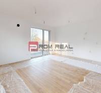 A bright room with large windows and wooden flooring in a 2-room apartment.