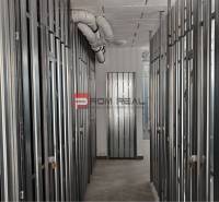 Storage spaces with metal doors and pipes on the ceiling in a 2-room apartment.