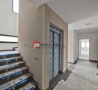 Hallway with an elevator, staircase, and plastic covering in a 2-room apartment.