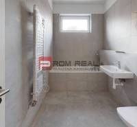 Bathroom in a 2-room apartment with a sink, toilet, and window for natural light.