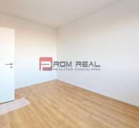 An empty room with wooden flooring and white walls in a 2-room apartment.
