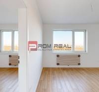 A bright interior of a 2-room apartment with wooden flooring and windows.