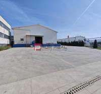 Warehouses and halls on Šúrska Street in Modra with a large concrete parking lot.