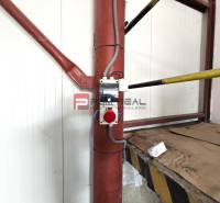 Interiors of warehouses and halls with a red pipe and electrical equipment.