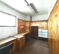Office space in a warehouse with wooden paneling and furniture.