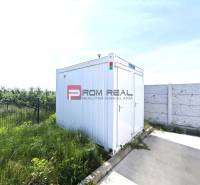 A white container next to the fence and concrete area on Šúrska Street in Modra.