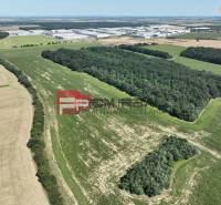 Aerial view of agricultural and forest land near Senecká Street and buildings.