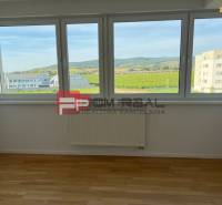A room with a light wooden floor surface and a view in a 4-room apartment.