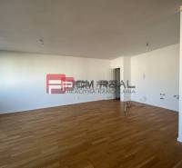 Spacious interior of a 4-room apartment with wooden flooring and white walls.