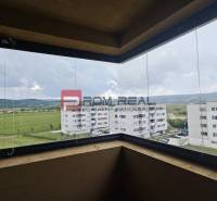 View from the balcony of a 4-room apartment over green fields and surrounding buildings in Pezinok.