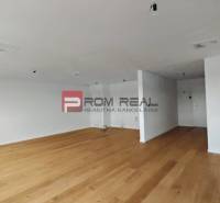 A spacious room with wooden flooring in a 4-room apartment, light walls, and simple furnishings.