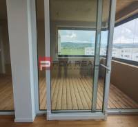 Glass doors lead to the loggia in a 4-room apartment with a view of the hills.