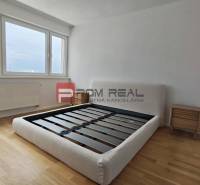 A bright bedroom with wooden flooring and a bed in a 4-room apartment.