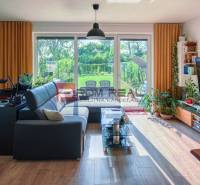 Living room in a family house with a fireplace, sofa, and glass doors to the garden.