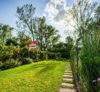 The garden of a family house in Slovenský Grob with a well-maintained lawn and pathway.