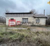 A small house on Partizánska Street, suitable for warehouses and halls, overgrown surroundings.