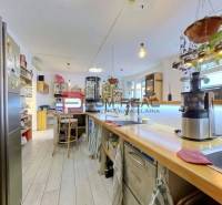 A kitchen in commercial premises with wooden furniture, appliances, and hanging plants.