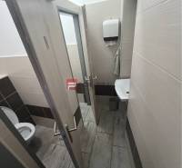 Restroom in commercial premises with a sink and a paper towel dispenser.