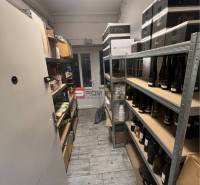 A narrow room with shelves on both sides full of bottles and packages.