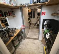 Storage space with shelves, barrels, and coffee machines in commercial premises.
