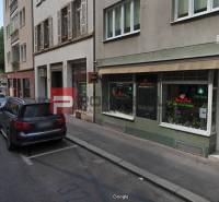 Grösslingova Street in Bratislava with parked cars and commercial spaces.
