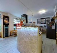 Interior of commercial premises with a counter, tables, and shelves with glasses.