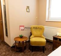 A hotel room with a chair, a table, a lamp, and a telephone, suitable for relaxation.