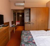 A room in a hotel or guesthouse with a television, wardrobe, and double bed.