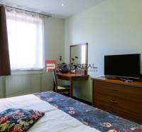 Room with a bed, table, and television in hotels and guesthouses.