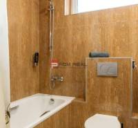 A bathroom with a bathtub and toilet in hotels and guesthouses, tiled with brown tiles.