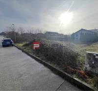 Land for residential use in Stupava on Bazova Street, sunny environment and a car by the road.