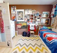 Children's room with hockey motifs in a 3-room apartment, decorations and a bed with a colorful throw.